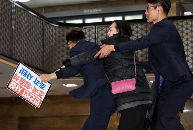 31일 오전 국회 본청에서 청와대 특감반 현안보고를 위해 국회 운영위원회 전체회의에 출석하는 임종석 대통령 비서실장과 조국 청와대 민정수석을 향해 대한애국당 관계자들이 항의시위를 하다 국회 관계자들의 저지를 받고 있다. 연합뉴스