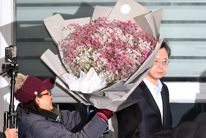 박근혜 정부의 '국정농단' 묵인 혐의와 국가정보원을 통한 불법사찰 혐의로 각각 기소돼 재판 중인 우병우 전 청와대 민정수석이 3일 오전 구속기한 만료로 석방돼 경기도 의왕 서울구치소를 나서며 한 지지자로부터 꽃다발을 받고 있다. 우 전 수석이 풀려나는 건 2017년 12월 15일 불법사찰 사건으로 구속된 이래 384일 만이다. 연합뉴스