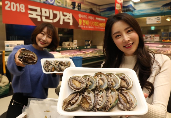 3일 이마트 서울 용산점에서 모델들이 ‘국민가격’ 행사에 들어가는 첫 수산식품인 전복을 선보이고 있다. 이마트 제공