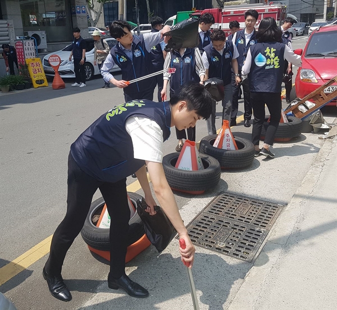 지난해 6월 하이트진로 공채 신입사원들이 첫 공식활동으로 부산역 인근 환경정화활동을 벌이고 있다. 부산역과 업소 주변 골목 상권을 돌며 오물 제거, 길거리 청소 등 거리 정화활동을 진행했다. 하이트진로 제공