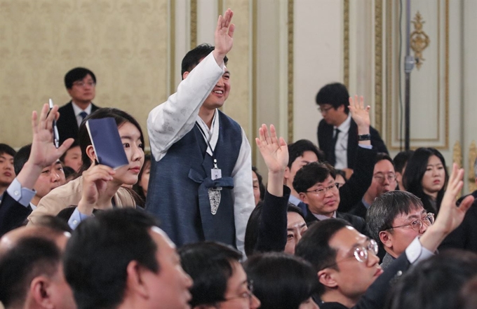 10일 오전 청와대 영빈관에서 열린 문재인 대통령 2019년 신년 기자회견에서 한 출입기자가 문 대통령에게 눈에 띄기 위해 한복을 입고 참석해 질문권을 얻으려 손을 들고 있다. 연합뉴스