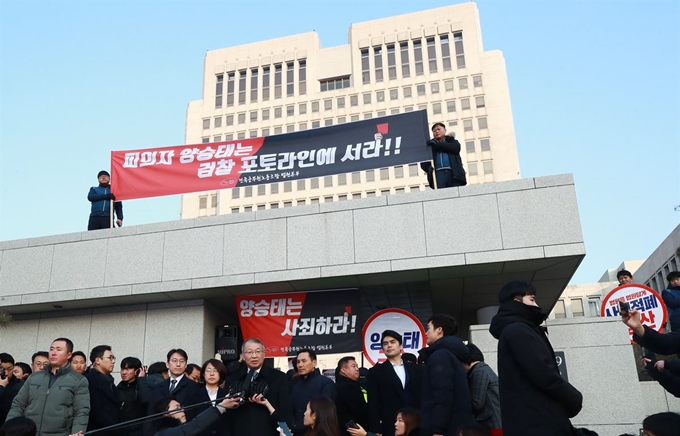 양승태 전 대법원장이 11일 오전 서울 서초동 대법원 앞에서 사법행정권 남용 의혹 관련 피의자 신분으로 검찰에 출석하기 전 입장을 밝히고 있다. 양 전 대법원장 뒤로 법원노조 조합원들이 펼침막과 손팻말을 든 채 양 전 대법원장을 규탄하고 있다. 연합뉴스