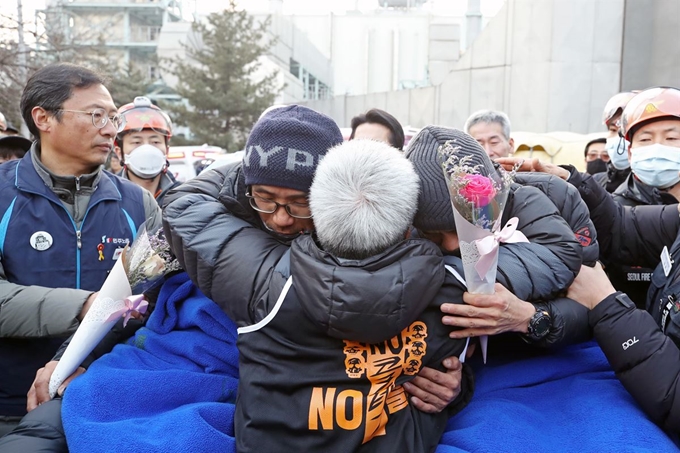 파인텍 노사 협상이 6차 교섭 끝에 극적으로 타결된 11일 파인텍 노동자인 홍기탁(오른쪽), 박준호씨가 서울 양천구 서울에너지공사 75m 높이 굴뚝에서 426일째 농성을 끝내고 내려온 뒤 노조원들과 포옹하고 있다. 연합뉴스