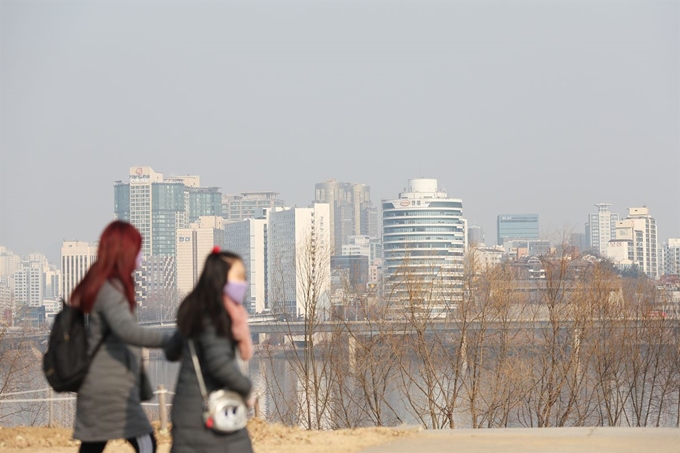 서울 지역 초미세먼지 농도 '나쁨' 수준을 보인 11일 오후 서울 여의도한강공원에서 마스크를 착용한 시민들이 산책을 하고 있다. 연합뉴스