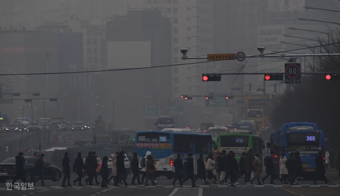 전국에 미세먼지가 기승을 부리는 14일 오전 서울 여의도에서 마스크를 쓴 출근길 시민들이 발걸음을 옮기고 있다. 배우한 기자