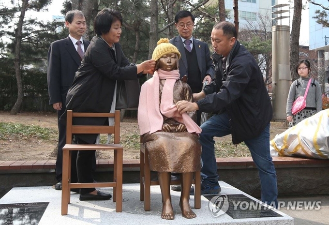 2017년 3월 1일 오전 대구시 중구 2·28 기념중앙공원에 설치한 '평화의 소녀상'에 시민들이 모자를 씌우고 목도리를 둘러매고 있다. 연합뉴스