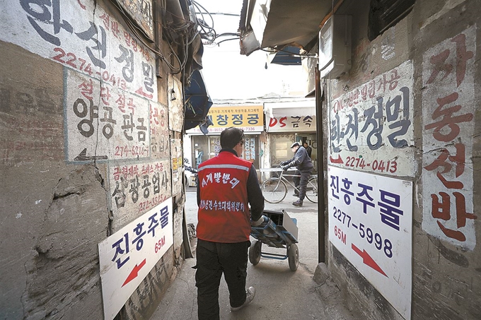 ‘재개발 반대’라고 적힌 조끼를 입은 한 상인이 서울 청계천변 일대를 지나고 있다. 청계천과 을지로 일대는 재개발을 위한 철거가 본격화되고 있다. 연합뉴스