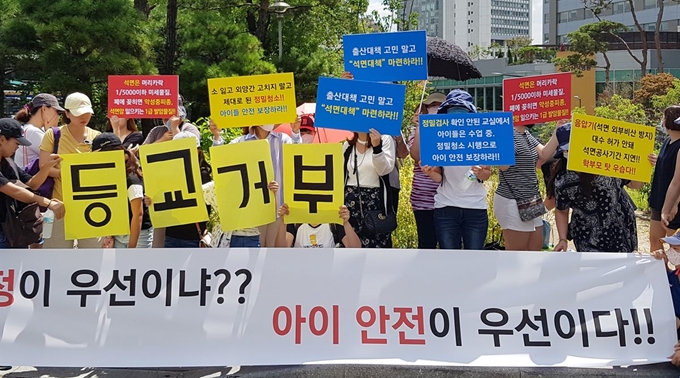 서울 신정초등학교 석면문제 학부모 비상대책위원회가 지난해 8월 10일 종로구 서울시교육청 앞에서 집회를 열고 석면제거 공사 취소에 따른 후속 대책과 조희연 교육감 면담을 요구하고 있다. 연합뉴스