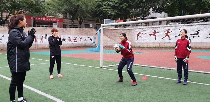 현대제철 레드엔젤스의 국가대표 골키퍼 김정미 선수(맨 왼쪽)가 중국 충칭(重慶)시에 위치한 따핑(大坪)중을 방문, 이곳 유소녀 축구 선수들을 지도하고 있다. 현대제철 제공