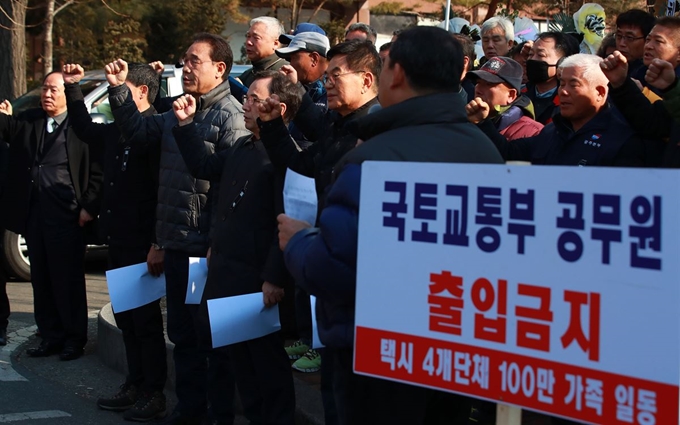 택시 4개 단체 비상대책위원회가 18일 오후 서울 여의도 국회의사당역 인근에서 기자회견을 하며 구호를 외치고 있다. 연합뉴스