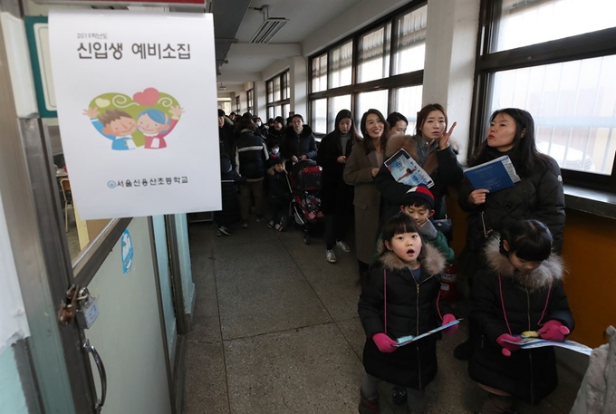 서울 공립초등학교 신입생 예비소집일인 지난 8일 서울 용산구 신용산초등학교에서 예비 초등학생과 학부모들이 교실 입장을 기다리고 있다. 연합뉴스