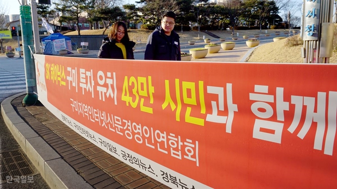 [저작권 한국일보]경북 구미시가 23일 SK하이닉스 반도체 유치를 위해 구미시내 거리 곳곳에 현수막을 내건 가운데 한 시민이 거리에 붙어 있는 현수막을 보고 있다. 추종호 기자 choo@hankookilbo.com