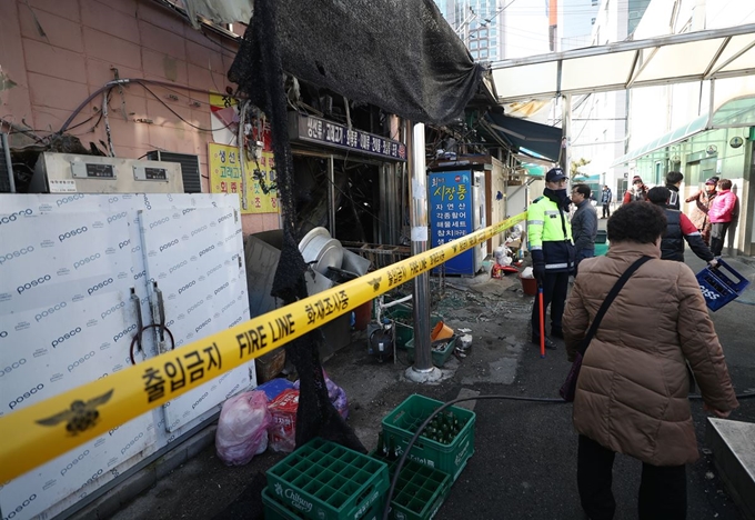 24일 오후 울산시 남구 농수산물도매시장 수산물종합동 화재 현장에서 상인이 발걸음을 돌리고 있다. 연합뉴스