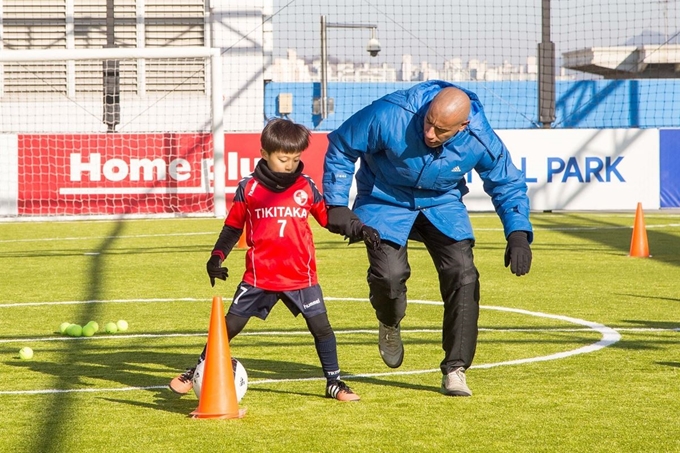 홈플러스 동대문점의 옥상 풋살파크에서 한 어린이가 외국인 코치에게 축구 수업을 받고 있다. 홈플러스 제공