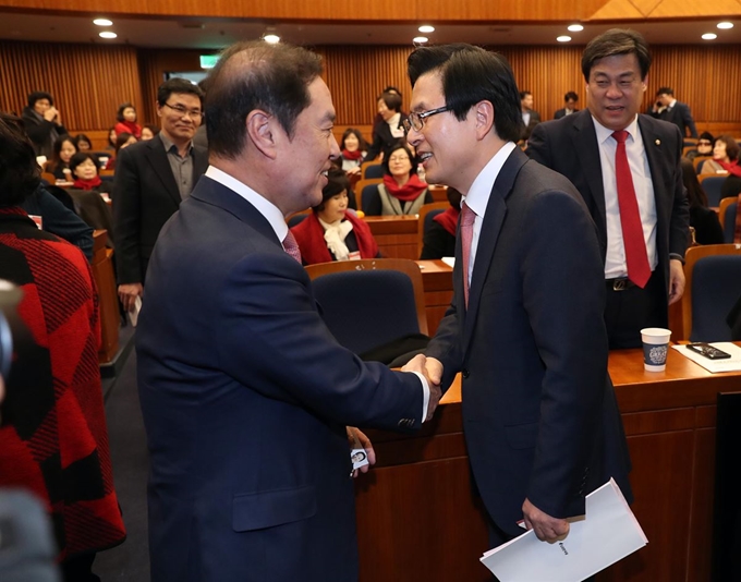 24일 오후 국회 헌정기념관에서 열린 자유한국당 전국지방의원 여성협의회 정기총회 및 발대식에서 회의 시작에 앞서 황교안 전 총리(오른쪽)와 김병준 비대위원장이 악수하고 있다. 연합뉴스