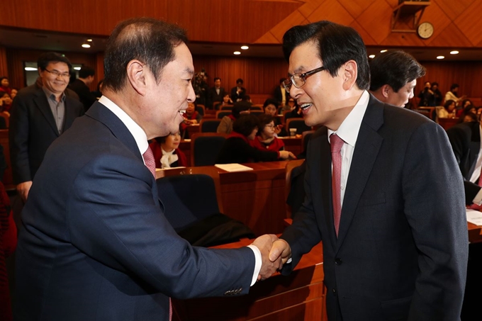 김병준 자유한국당 비상대책위원장과 한국당 당권 도전에 나선 황교안 전 국무총리가 24일 오후 서울 여의도 국회 헌정기념관에서 열린 '전국 지방의원 여성협의회 정기총회 및 발대식'에서 악수를 나누고 있다. 뉴스1