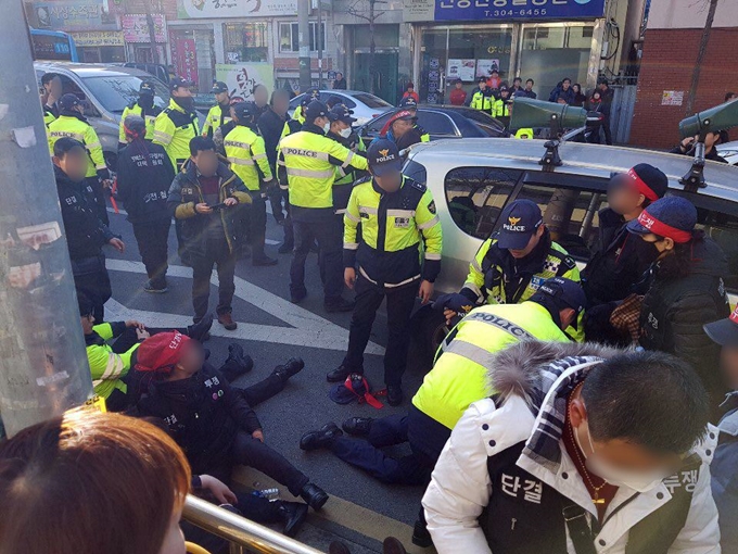 24일 오후 3시 46분쯤 부산 사상구 덕포동에서 재개발 반대 도로 행진 중 집회 주최 측 차량이 덮치는 바람에 부상 당한 집회 참가자들이 도로에 앉아 있다. 이 사고로 경찰관과 집회 참가자 20여명이 다쳤다. 부산경찰청 제공