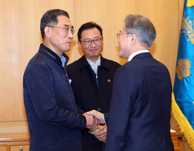 문재인 대통령이 25일 오후 청와대에서 김주영 한국노총 위원장(왼쪽)과 악수하고 있다. 가운데는 김명환 민주노총 위원장. 연합뉴스