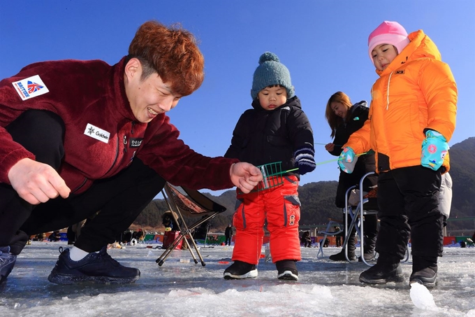 인제 빙어축제 나흘째인 29일 축제장을 찾은 방문객이 자녀와 함께 빙어 얼음낚시를 하고 있다. 연합뉴스