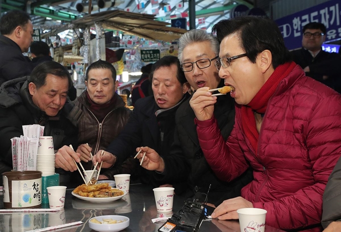 자유한국당 당권에 도전한 황교안 전 총리가 31일 오후 서울 중구 광장시장을 방문해 빈대떡을 먹고 있다. 연합뉴스