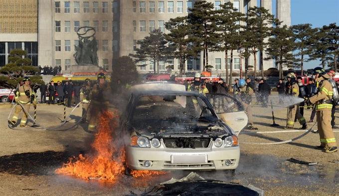 1일 오전 서울 영등포구 국회 잔디밭에서 승용차에 화재가 발생, 소방대원들이 진화 작업을 하고 있다. 연합뉴스