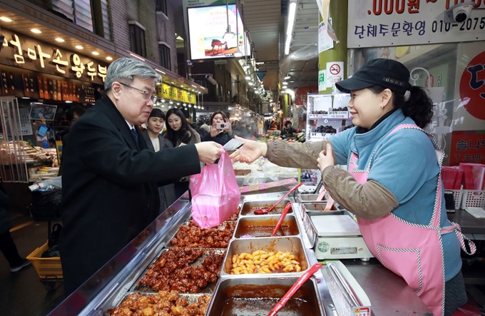 이재갑(왼쪽) 고용노동부 장관이 지난달 30일 오후 서울 마포구 망원시장을 방문해 온누리상품권으로 물건을 사고 있다. 고용노동부 제공