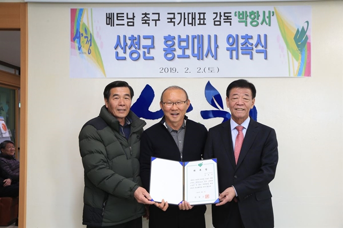 산청군은 지난 2일 베트남의 ‘국민 파파’ 박항서 베트남 축구 국가대표팀 감독을 홍보대사로 위촉했다. 군은 박 감독의 고향 생초면을 ‘베트남 마을’로 조성하는 등 박 감독을 베트남 관광객 유치와 농특산물 교류, 국내 스포츠 마케팅 활성화 등 다양한 분야에서 산청 홍보를 맡기기로 했다. 박항서(가운데) 감독과 이재근(오른쪽 첫 번째) 산청군수가 홍보대사 위촉식을 가진 뒤 기념촬영을 하고 있다. 산청군 제공