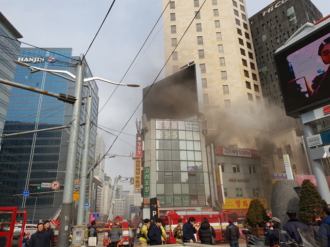 8일 오후 서울 명동 포스트타워 인근 식당건물에 화재가 발생, 출동한 소방대원들이 화재를 진압하고 있다. 독자촬영 제공=연합뉴스