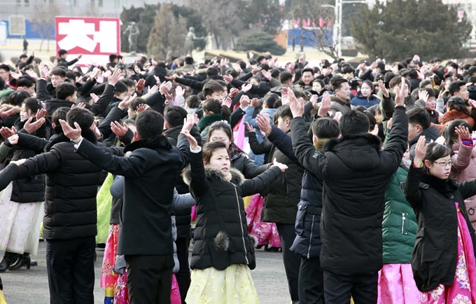 북한 평양의 개선문 광장에서 8일(현지시간) 건군절(인민군 창건일) 71주년 기념 축하 무도회가 열려 한복 위에 패딩 등 겨울 옷을 입은 청년 및 학생들이 춤을 추고 있다. AP 연합뉴스