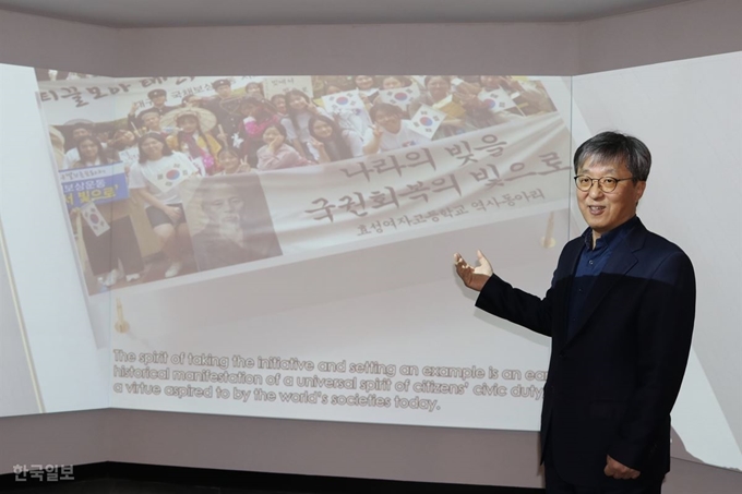 김영철 국채보상운동기념사업회 공동대표가 12일 대구 중구 국채보상운동기념관에서 1997년 외환위기 때 금모으기운동의 영상을 배경으로 국채보상운동 연혁을 설명하고 있다. 윤희정기자 yooni@hankookibo.com