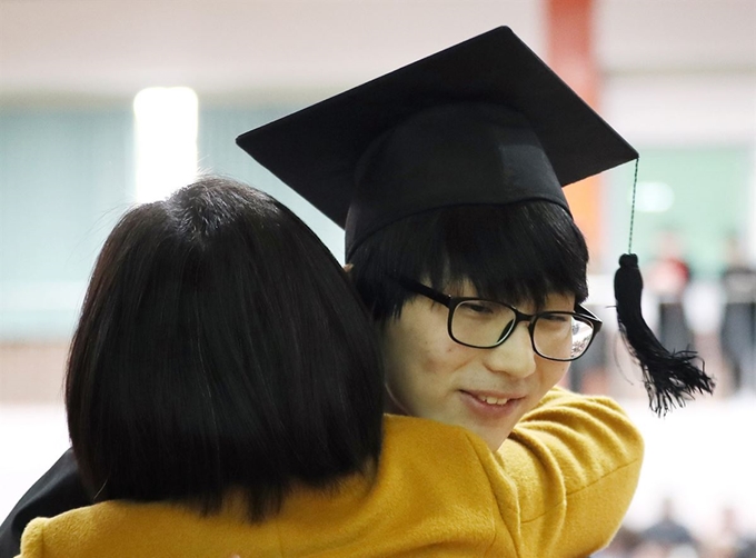 12일 오전 서울 용산구 선린인터넷고등학교에서 열린 제111회 졸업식에서 한 졸업생이 졸업장을 받은 뒤 담임선생님과 포옹을 하고 있다. 연합뉴스