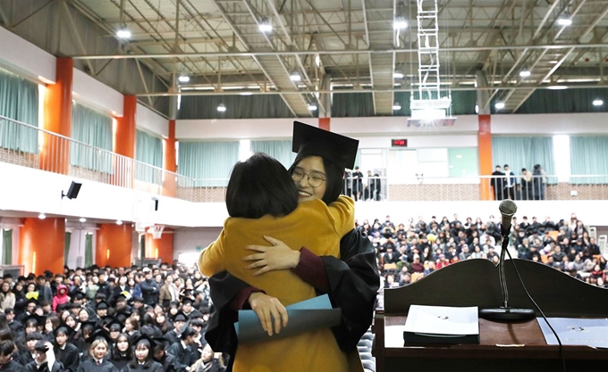 12일 오전 서울 용산구 선린인터넷고등학교에서 열린 제111회 졸업식에서 한 졸업생이 졸업장을 받은 뒤 담임선생님과 포옹을 하고 있다. 연합뉴스