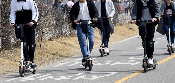 전동킥보드를 타고 도로 위를 달리는 사람들. 한국일보 자료사진