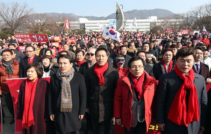 자유한국당 김진태(앞줄 왼쪽 두번째부터), 오세훈, 황교안 당 대표 후보가 16일 오전 경남 창원시 의창구 경남도청 앞에서 열린 '댓글조작 김경수 규탄대회'에 참석해 애국가를 부르고 있다. 창원=연합뉴스