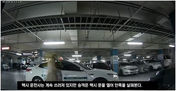 지난해 12월 8일 오전 인천 남동구 한 아파트단지 지하주차장에서 30대 승객이 자신과 다투던 택시기사가 쓰러진 상황에서 택시 문을 열어 안쪽을 살펴보고 있다. 동영상 캡처