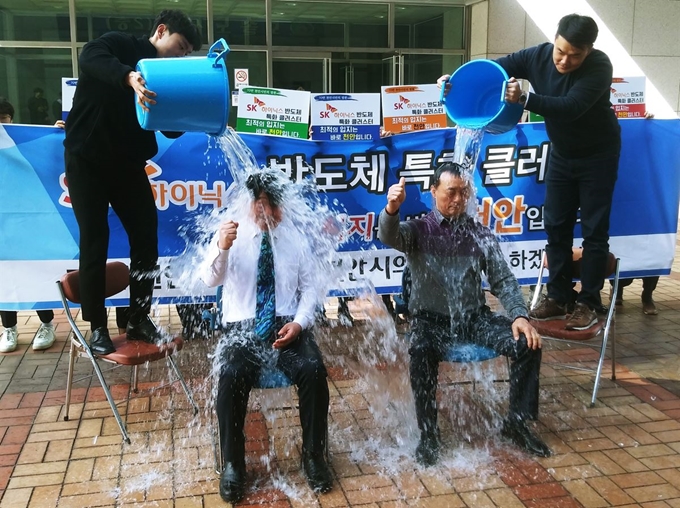 18일 오전 충남 천안시의회 앞에서 SK하이닉스 반도체 공장 천안유치를 촉구하는 ‘아이스버킷 챌린지’에 나선 천안시의회 인치견 의장(왼쪽)과 천안 구도심 명동ㆍ대흥로상인회 이명수고문이 영하의 날씨에 얼음물을 세례를 받고 있다. 이준호 기자 junhol@hankookilbo.com