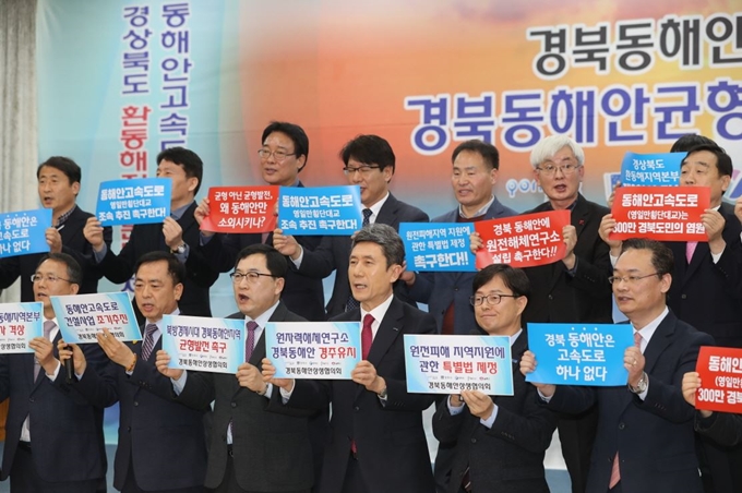 경북 포항과 경주, 영덕, 울진, 울릉 등 동해안 5개 지역 단체장과 유관기관 관계자들이 원자력해체연구소 경주 유치와 동해안고속도로 조기 건설을 촉구하는 내용의 플래카드를 들고 구호를 외치고 있다. 포항시 제공