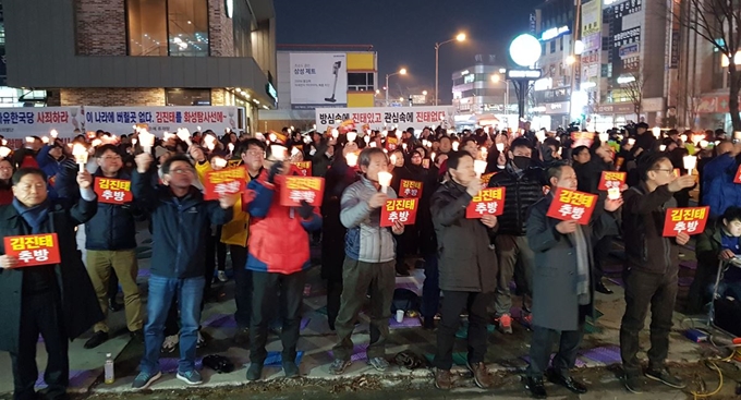 춘천지역 시민단체 회원 등이 21일 저녁 춘천시 석사동 자유한국당 김진태 의원 지역구 사무실 건너편에서 촛불집회를 열고 국회의원직 사퇴를 요구하고 있다. 박은성 기자