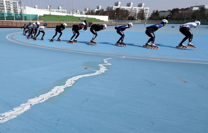 지난 21일 오후 인천시 연수구 동춘인라인롤러경기장에서 인라인스케이트 선수들이 경기장 바닥 균열을 피해 질주하며 훈련하고 있다. 연합뉴스