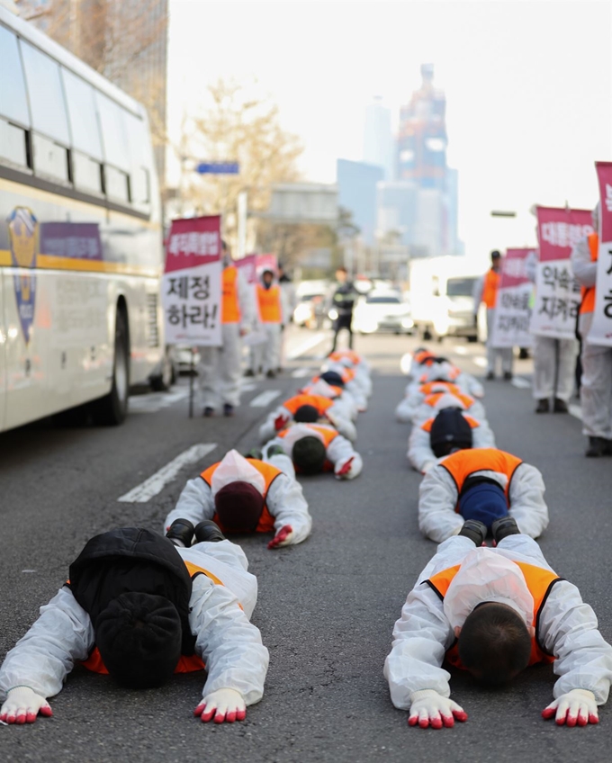 전국공무원노동조합 김주업 위원장(앞줄 오른쪽)과 조합원들이 2월 14일 오전 서울 마포구 마포대로에서 중구 민주노총 방면으로 해직자 복직을 촉구하며 오체투지 행진을 하고 있다. 연합뉴스