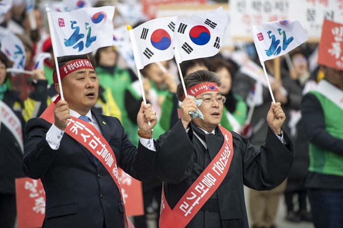 22일 경북 울릉군 도동항 소공원에서 일본 시마네현의 다케시마(일본이 주장하는 독도의 명칭)의 날 행사를 강력 규탄하는 결의대회가 열린 가운데 김병수 울릉군수(오른쪽)와 이재도 경북도의원(왼쪽)이 태극기를 흔들고 있다. 울릉군 제공.