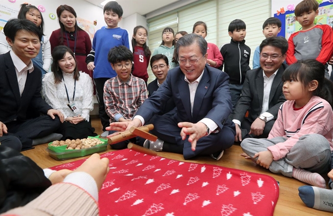 문재인 대통령이 2월19일 노원구 월계문화복지센터에서 열린 포용국가 사회정책 대국민 보고회에 앞서 초등학생 방과후 돌봄시설을 방문해 아이들과 윷놀이를 하고 있다. 청와대사진기자단