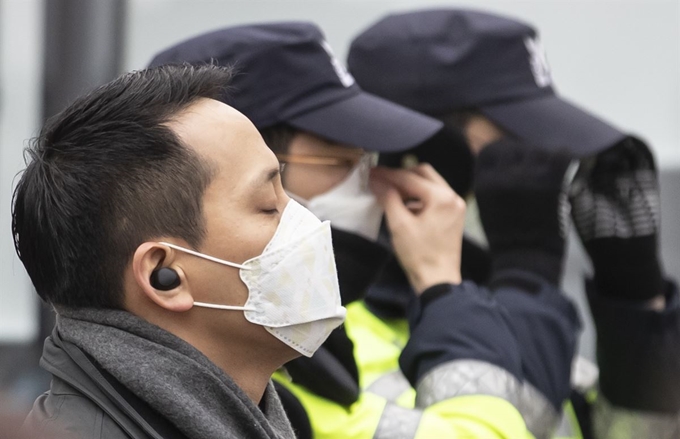 서울과 경기, 충청 등 전국 곳곳에 초미세먼지 주의보가 발령된 25일 서울 세종로사거리에서 마스크를 쓴 시민과 경찰이 길에 서 있다. 연합뉴스