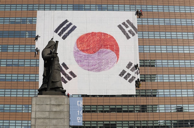 3ㆍ1운동 100주년을 앞두고 26일 오후 서울 광화문 교보생명빌딩 외벽에 대형 태극기 설치 작업이 한창이다. 연합뉴스