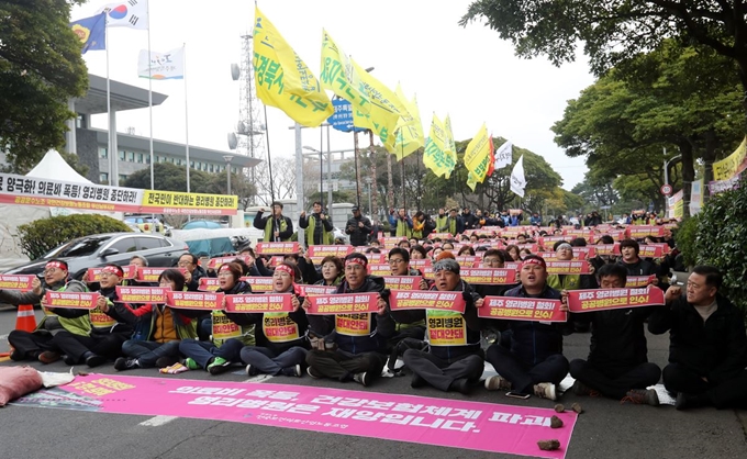 27일 제주도청 앞 도로에서 열린 '제주도 영리병원 철회와 원희룡 도지사 퇴진 촉구' 결의대회에서 참가자들이 구호를 외치고 있다. 연합뉴스.