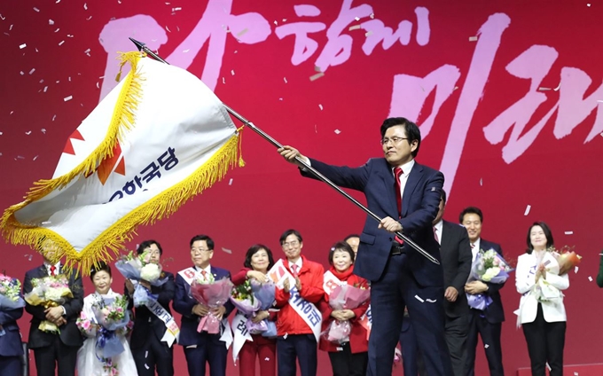 27일 경기도 고양시 킨텍스에서 열린 자유한국당 전당대회에서 당 대표로 선출된 황교안 전 총리가 당기를 흔들고 있다. 고양=연합뉴스