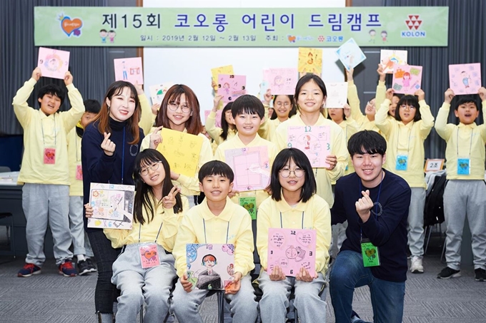 지난달 12일 1박 2일로 열린 ‘제15회 코오롱 어린이 드림캠프’에 참가한 학생들이 각자의 장래희망을 그린 ‘그림시계’를 들고 기념촬영을 하고 있다. 코오롱그룹 제공