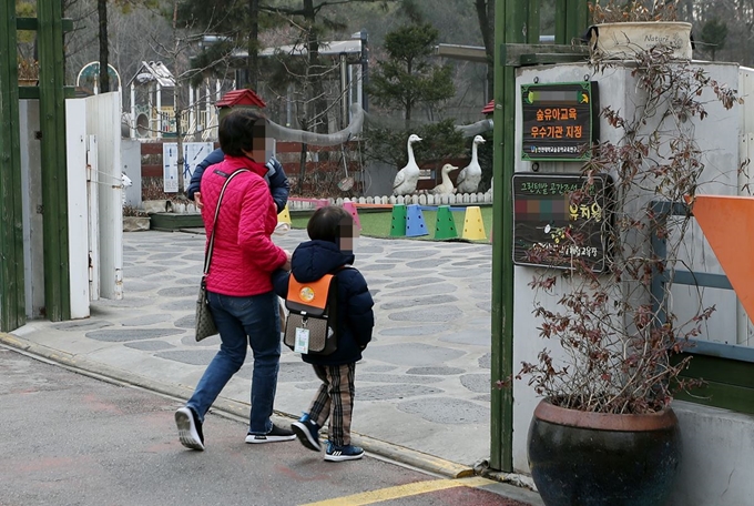 한국유치원총연합회가 개학 연기를 강행한 4일 오전 개학을 연기한 인천시 남동구 한 사립유치원에서 한 학부모가 아동과 함께 등원하고 있다. 이 사립유치원은 이날 개학은 연기했지만 돌봄서비스는 운영하기로 했다. 연합뉴스