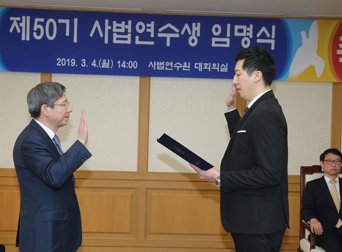 4일 오후 고양 사법연수원 대강당에서 열린 제50기 사법연수생 임명식에서 혼자 입소하는 조우상(오른쪽.33)씨가 김문석 사법연수원장에게 선서하고 있다. 연합뉴스