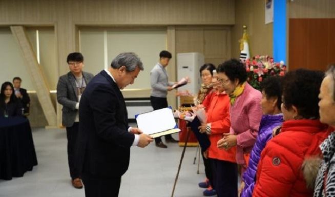 유근기 곡성군수가 곡성군 겸면 마전리 성인문해학습반 어르신에게 초등학력 인정서를 전달하고 있다. 곡성군 제공